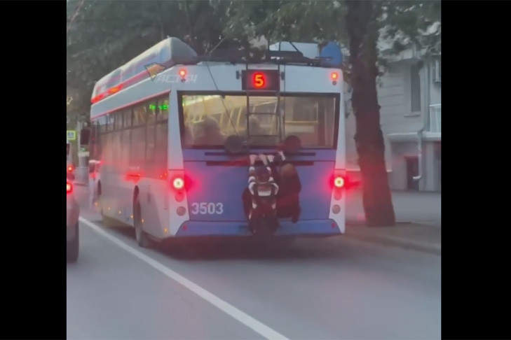 В Новосибирске школьники зацепились за троллейбус и поехали по центру