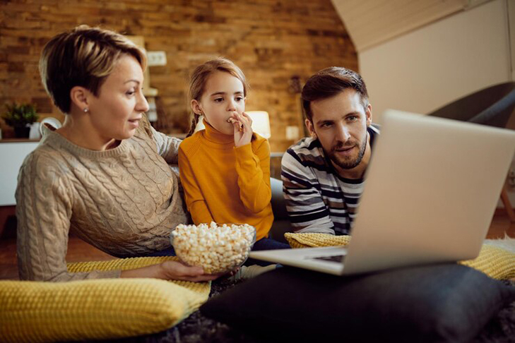 family_using_laptop_while_eating_popcorn_relaxing_home_637285_12226.jpg